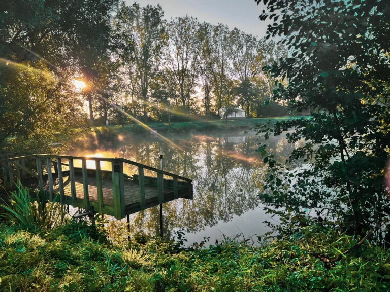 de vijver met een camper bij zonsopkomst.